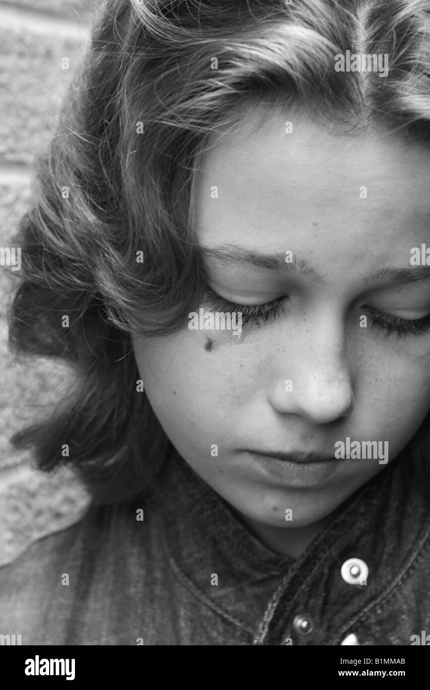 Young teenage girl looking sad crying tear with smudge eye mascara make up Stock Photo