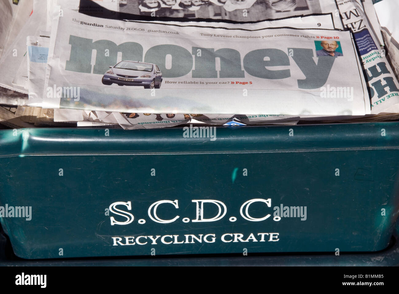 Old newspapers loaded into creates waiting for recycling outside a