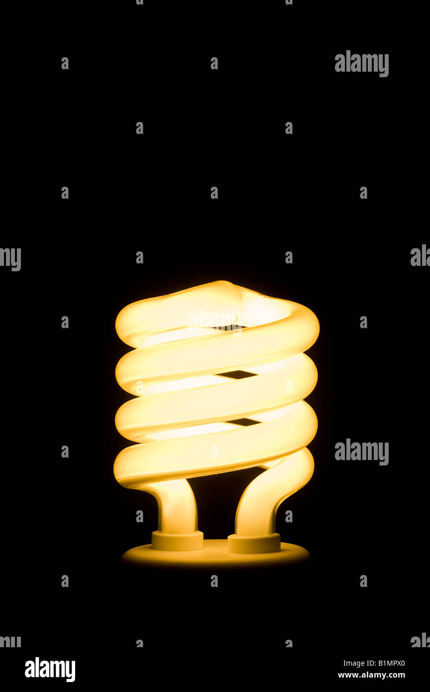 Energy saving fluorescent light bulb on black background Space for text ...