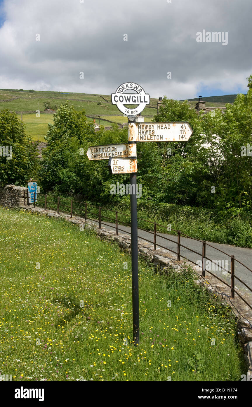 Old fashioned roadsign set in field in countryside at the top of Dent in Cumbria inside the Yorkshire Dales Stock Photo