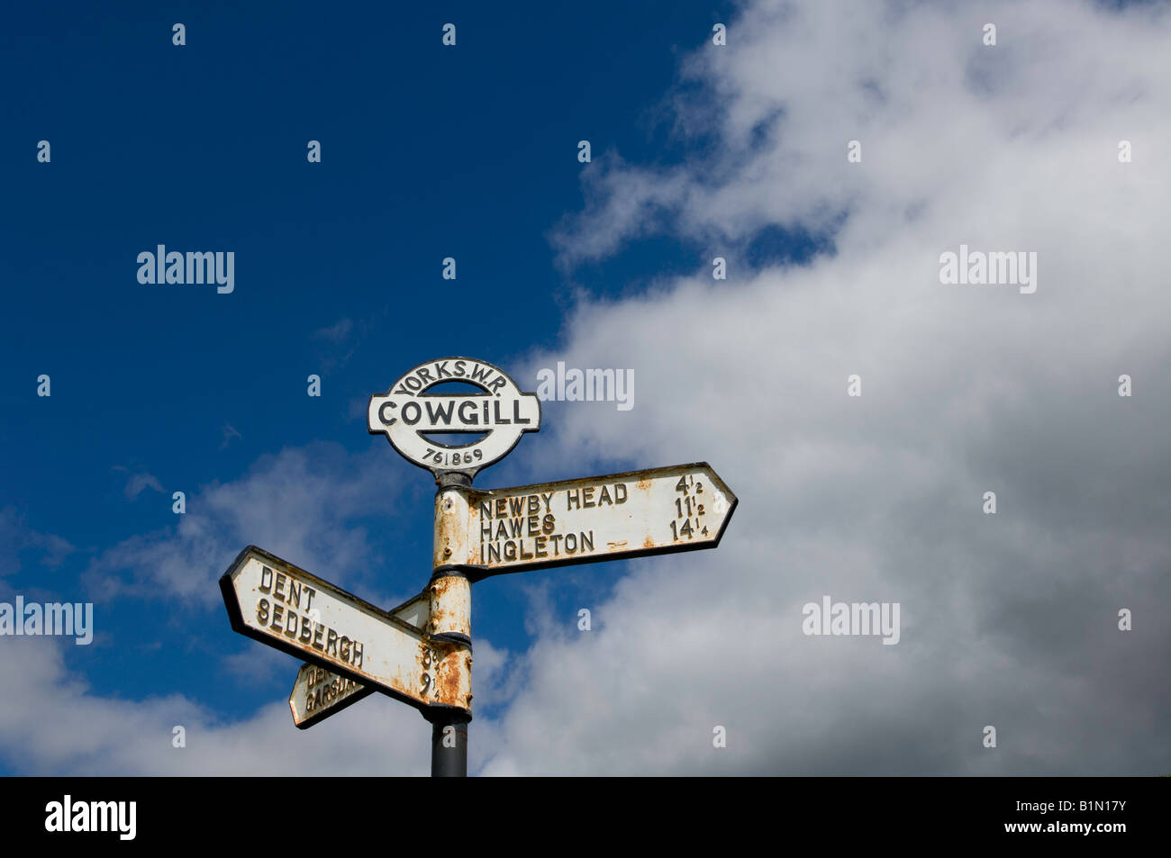 Old fashioned roadsign set in field in countryside at the top of Dent in Cumbria inside the Yorkshire Dales Stock Photo