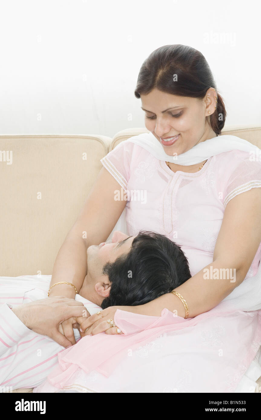 Mid adult man lying on the lap of a mid adult woman and smiling Stock ...