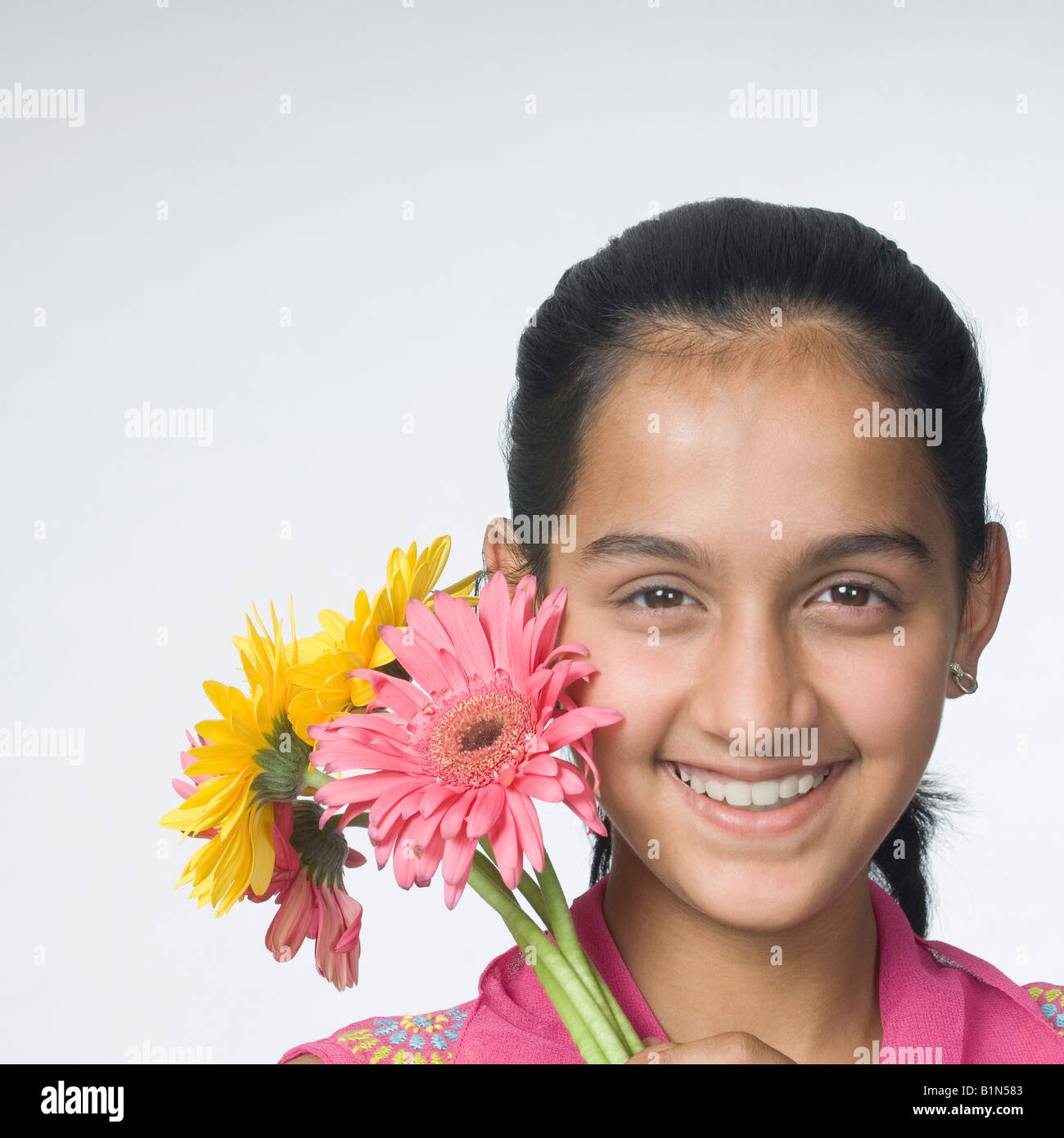 Portrait of a teenage girl holding flowers and smiling Stock Photo - Alamy