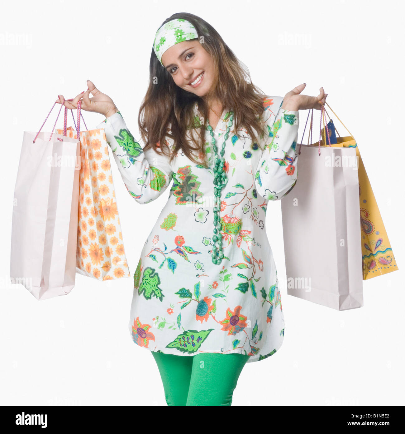 Portrait of a young woman holding shopping bags and smiling Stock Photo ...