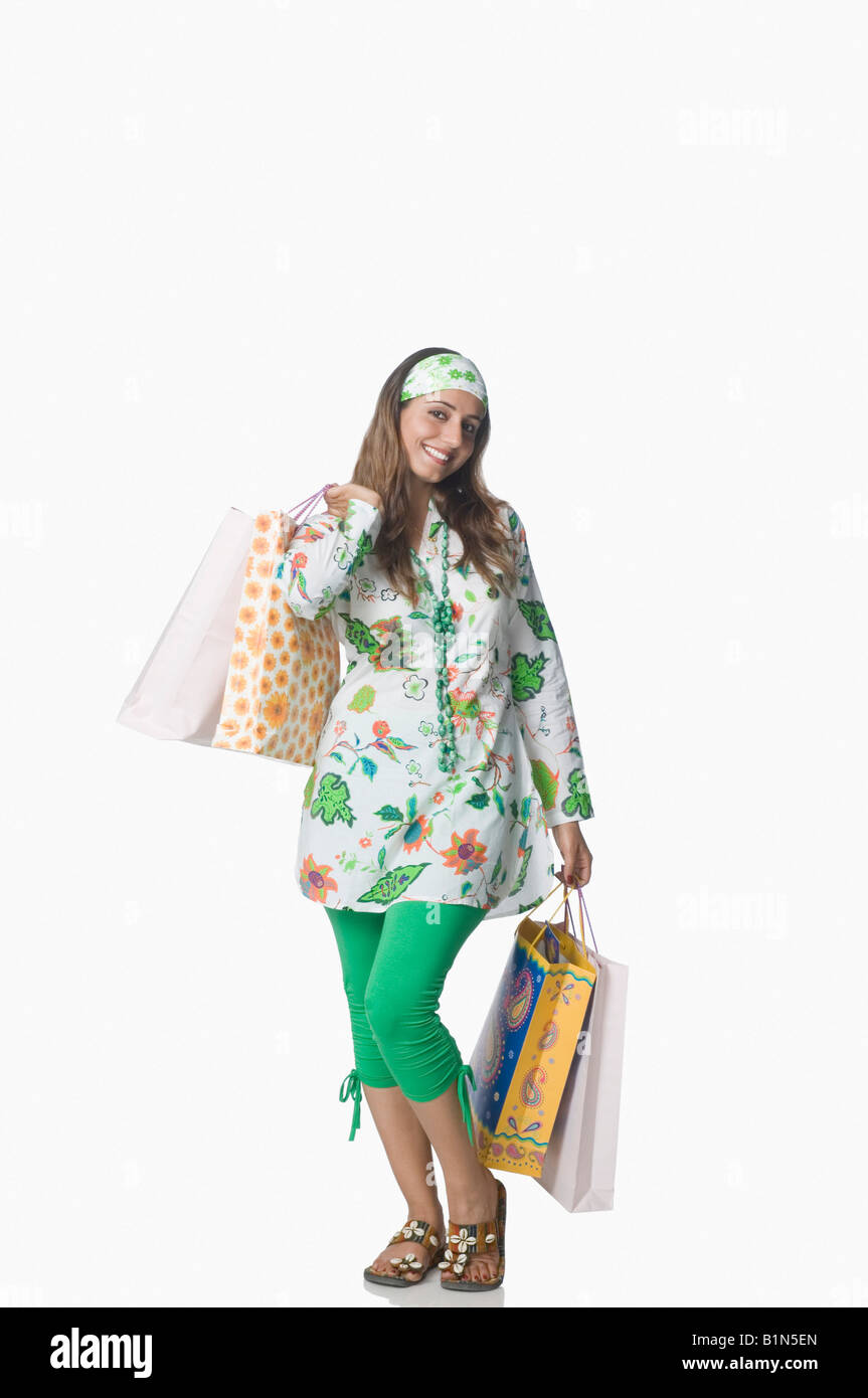 Portrait of a young woman holding shopping bags and smiling Stock Photo ...