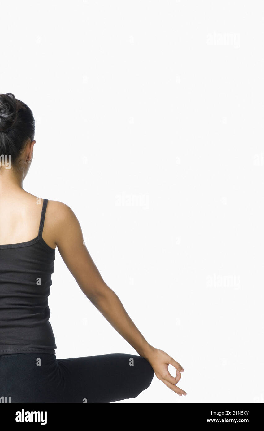Rear view of a young woman meditating Stock Photo - Alamy
