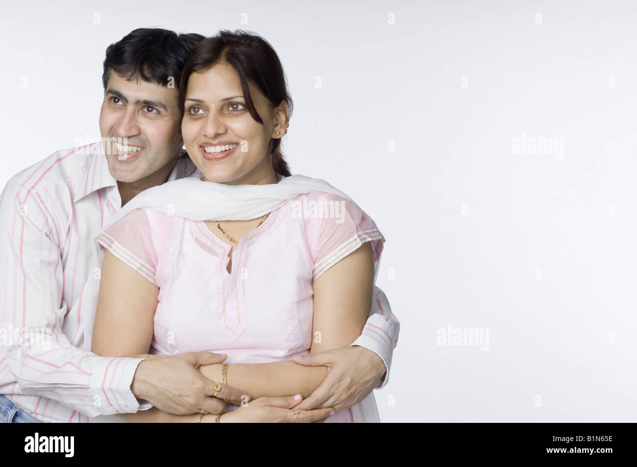 Close-up of a mid adult man hugging a mid adult woman from behind Stock ...