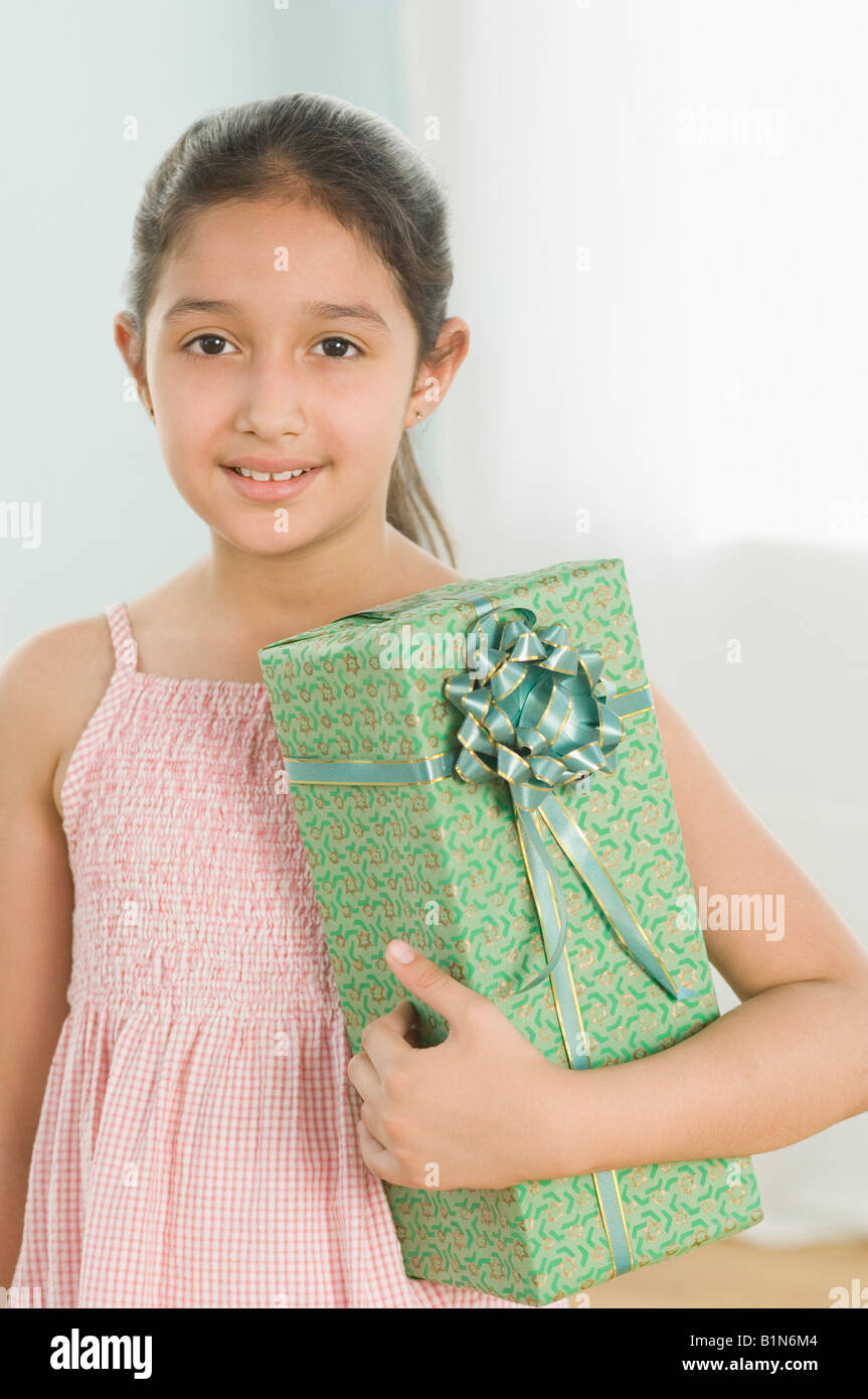 Portrait of a girl holding a gift and smiling Stock Photo - Alamy