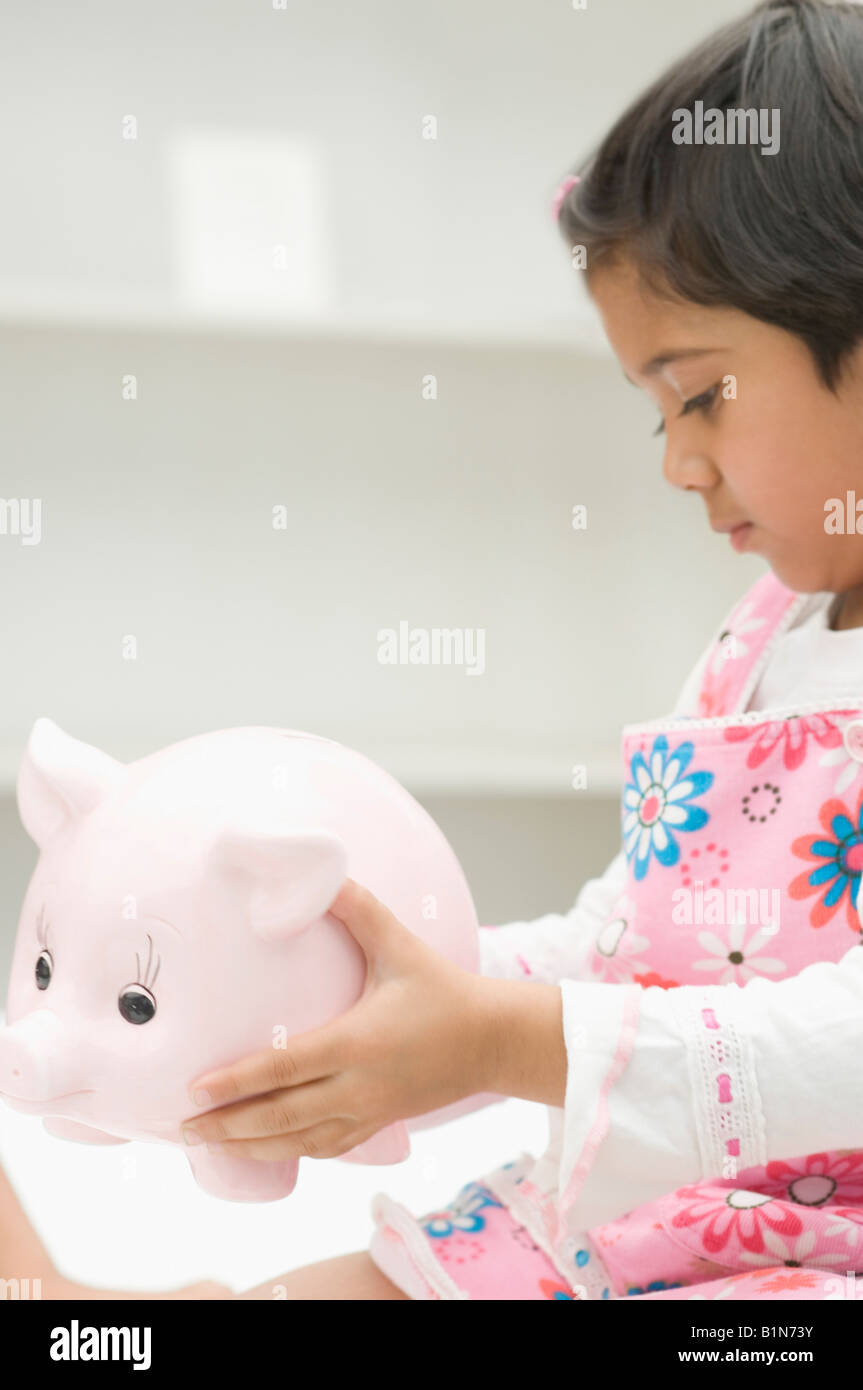 Indian girl holding piggy bank hi-res stock photography and images - Alamy