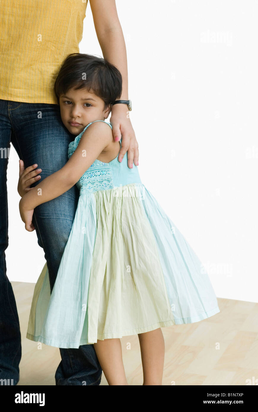 Portrait of a girl hugging her mother's leg Stock Photo