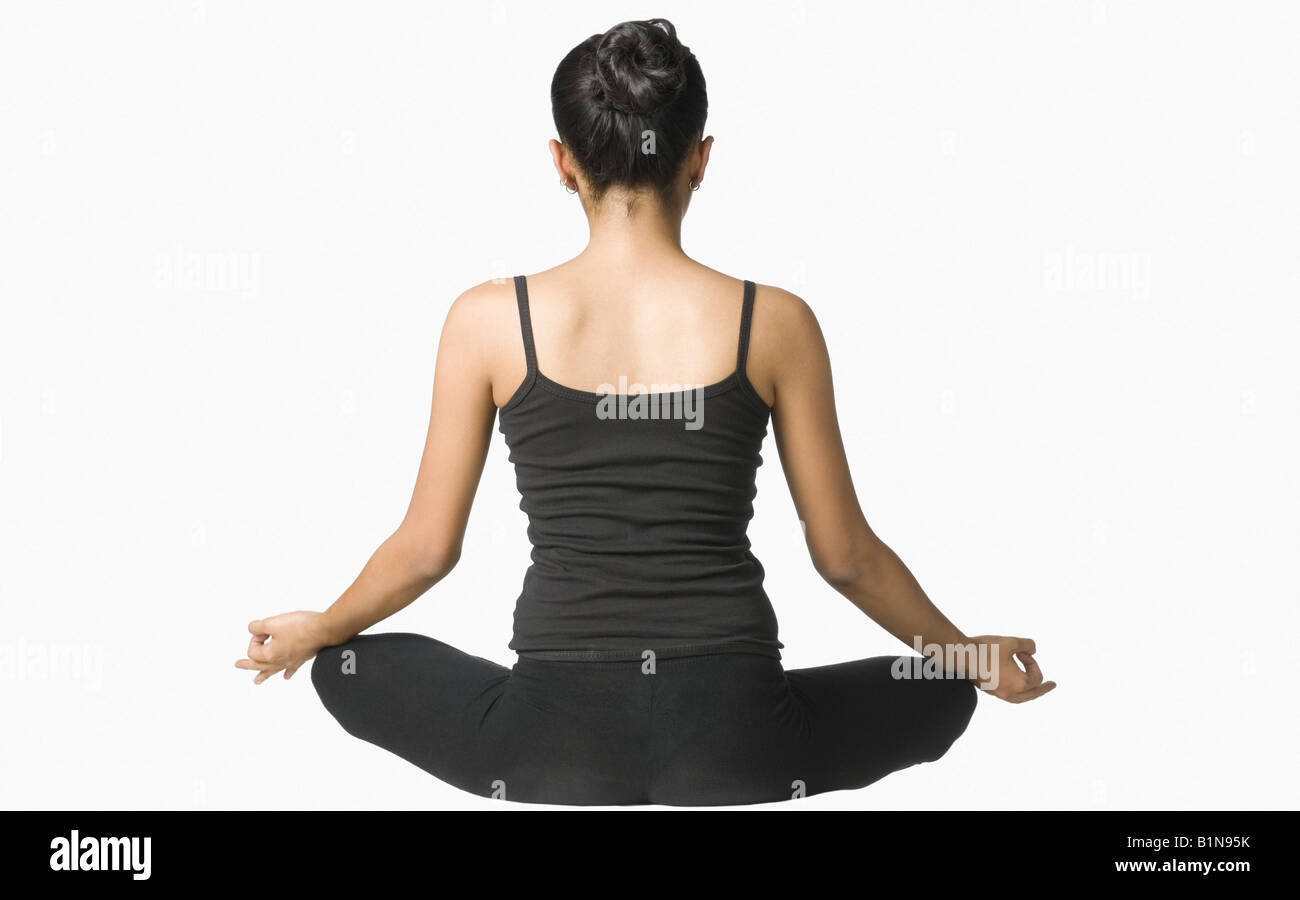 Rear view of a young woman meditating Stock Photo - Alamy