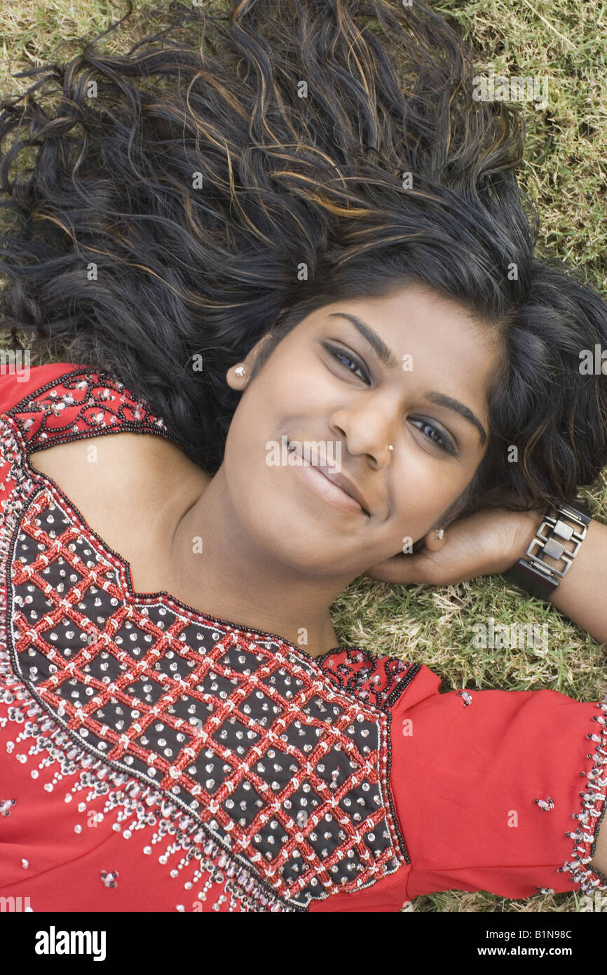 Portrait of a young woman lying on grass and smiling Stock Photo - Alamy