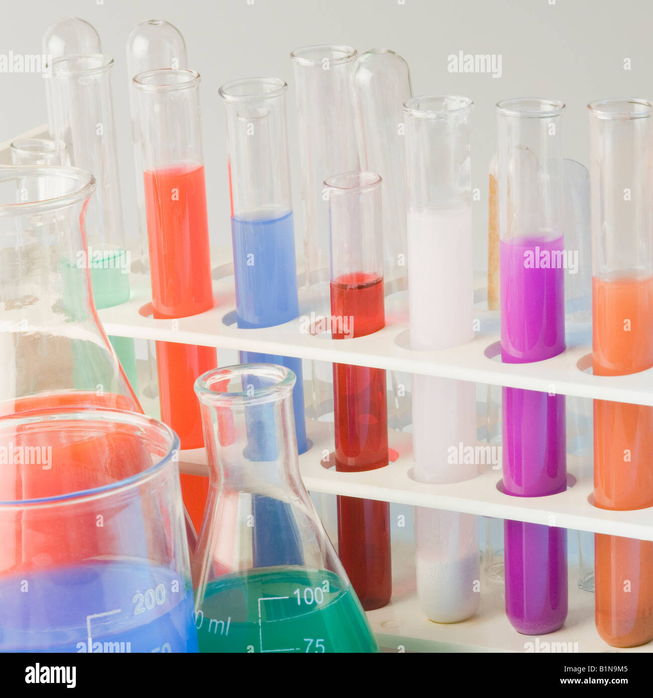 Close-up of test tubes in a test tube rack with conical flasks Stock Photo