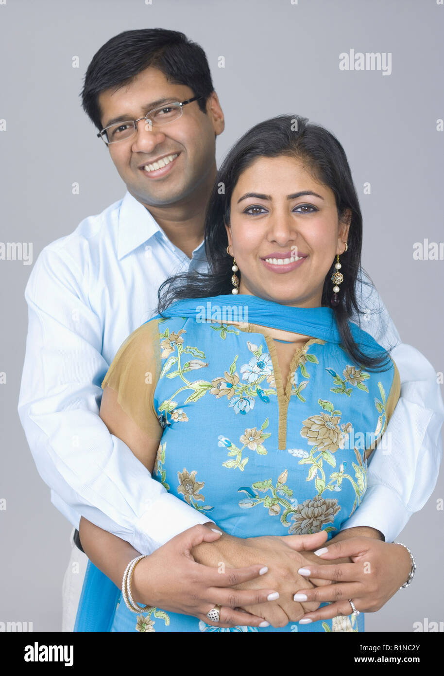 Portrait of a mid adult man hugging a mid adult woman from behind and ...