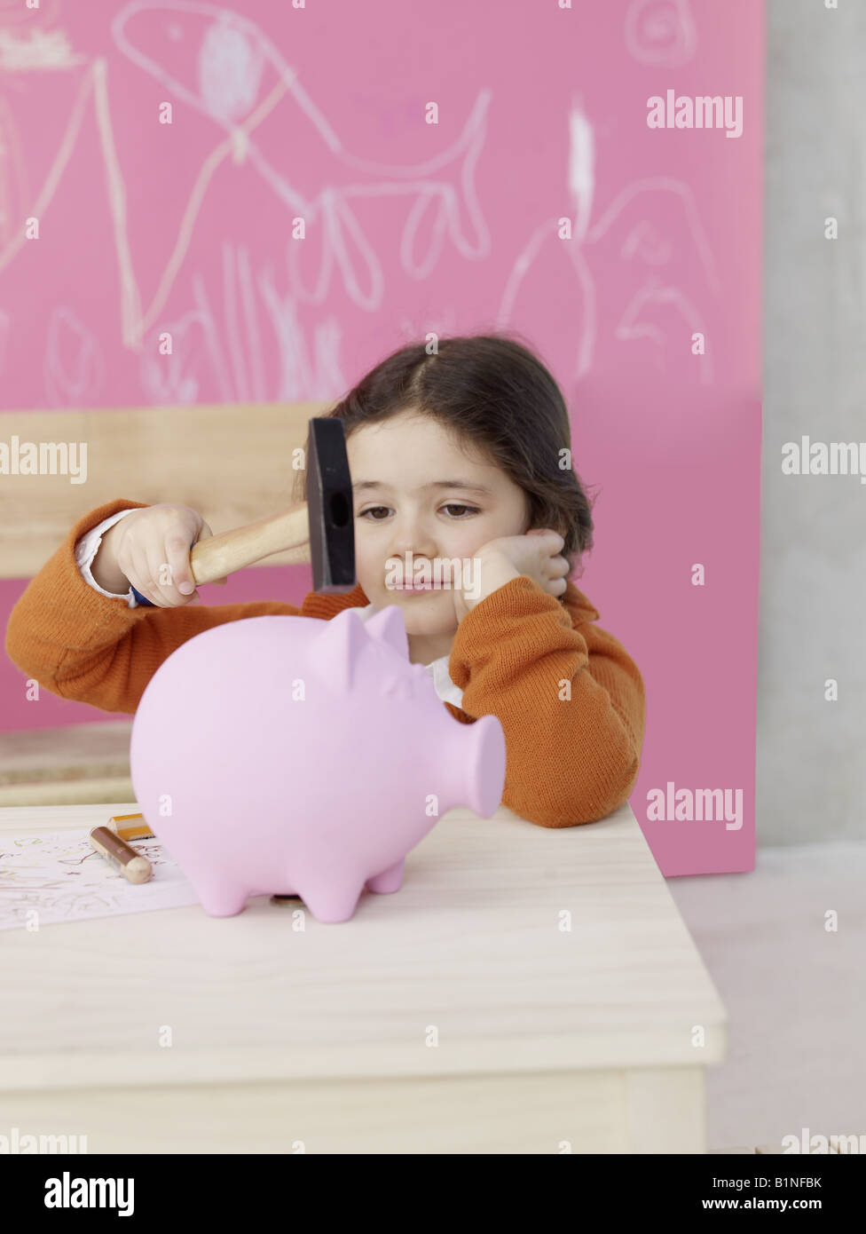 Girl with hammer and piggy bank Stock Photo - Alamy