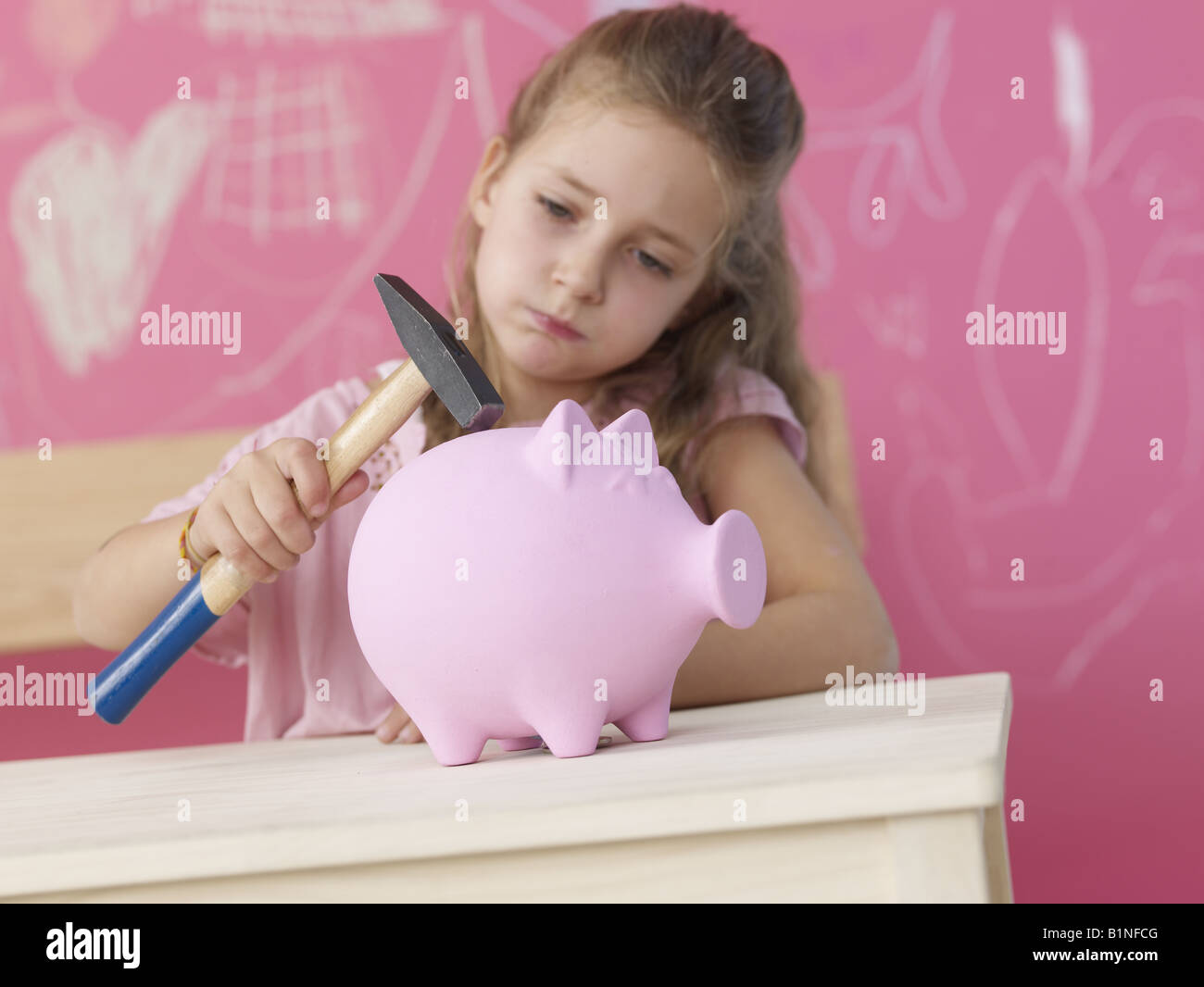 Blonde girl with hammer and piggy bank Stock Photo - Alamy
