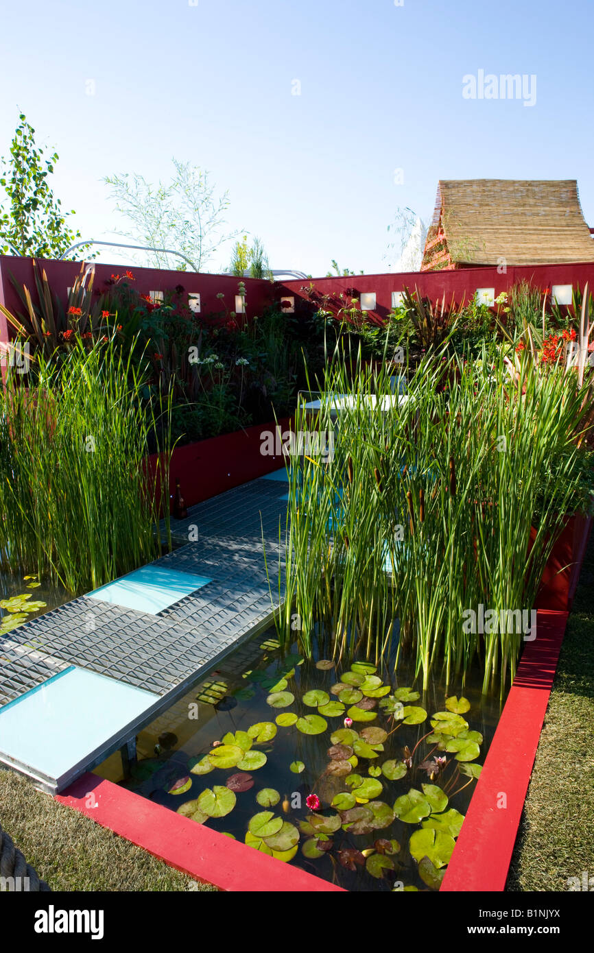 small garden pond with path made of metal grid Stock Photo Alamy