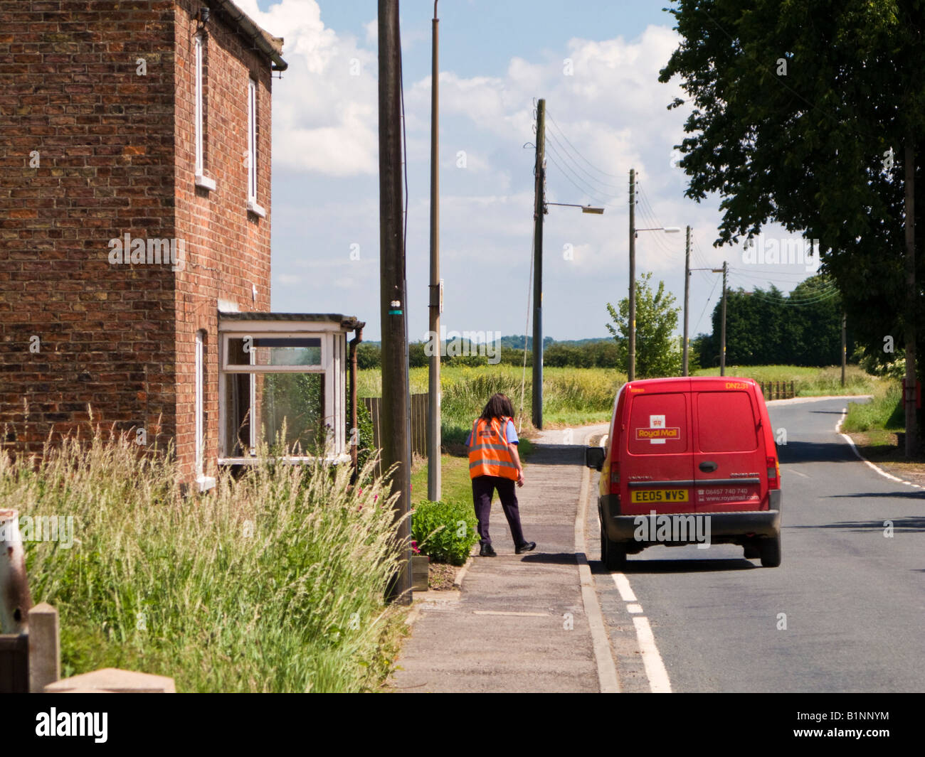 Post woman and red Post van on rural delivery round in East Yorkshire England UK Stock Photo
