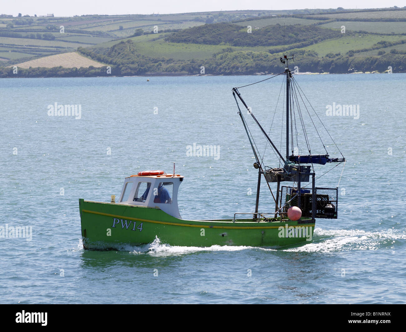 Small fishing boat heading out to sea Stock Photo