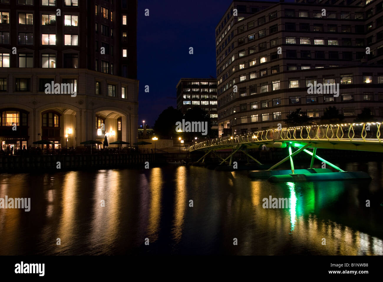 Illuminated bridge and office buildings at night in Canary Wharf ...