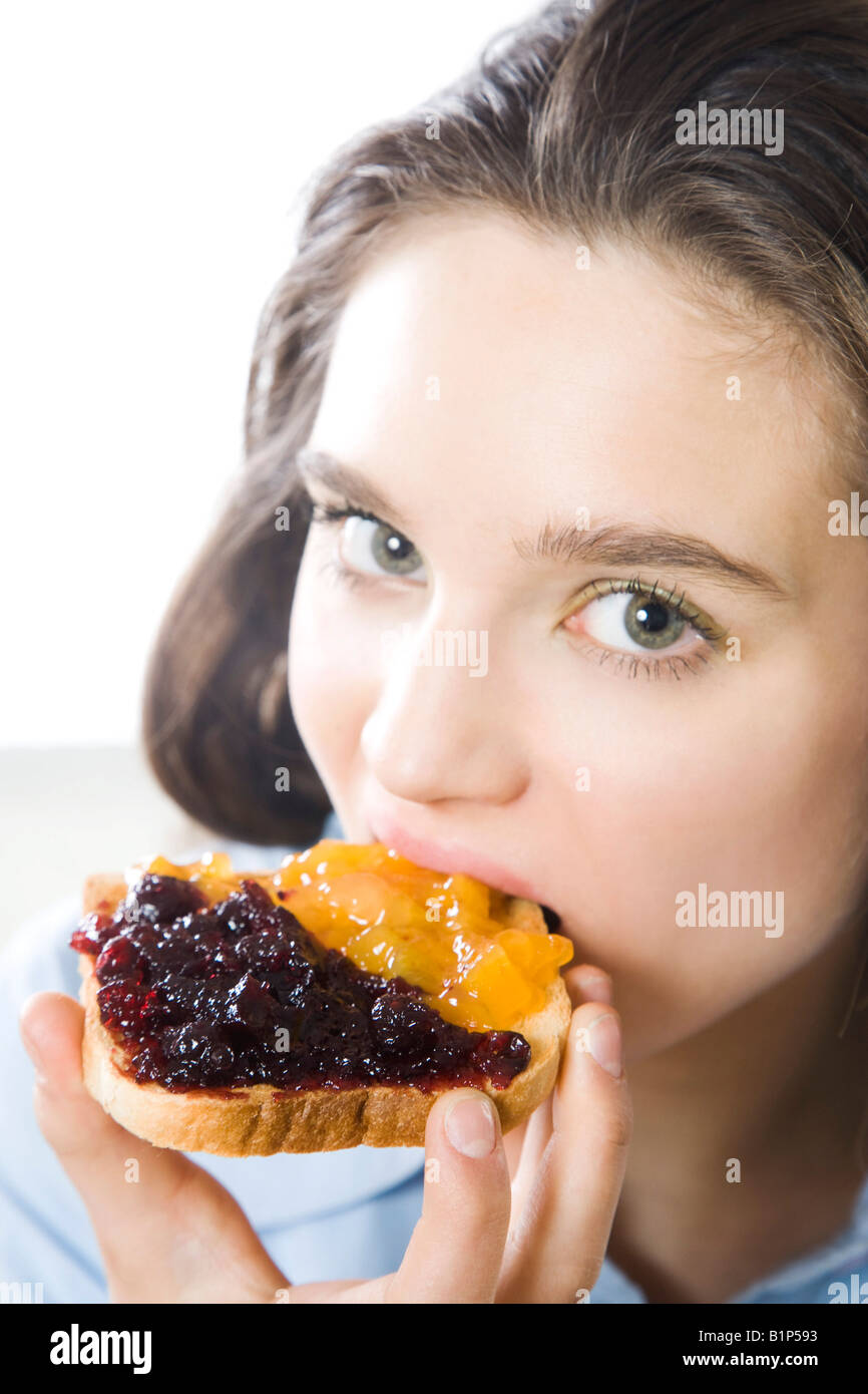 Young woman eating toast Stock Photo - Alamy