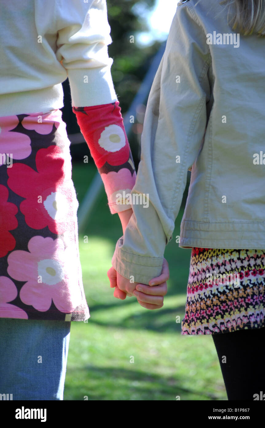 Photograph of two friends holding hands whilst playing games outside