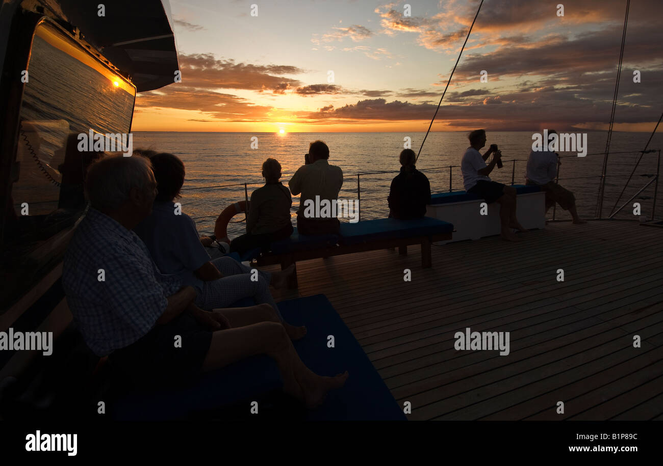 Tourists aboard ship with sunset, galapagos islands Stock Photo