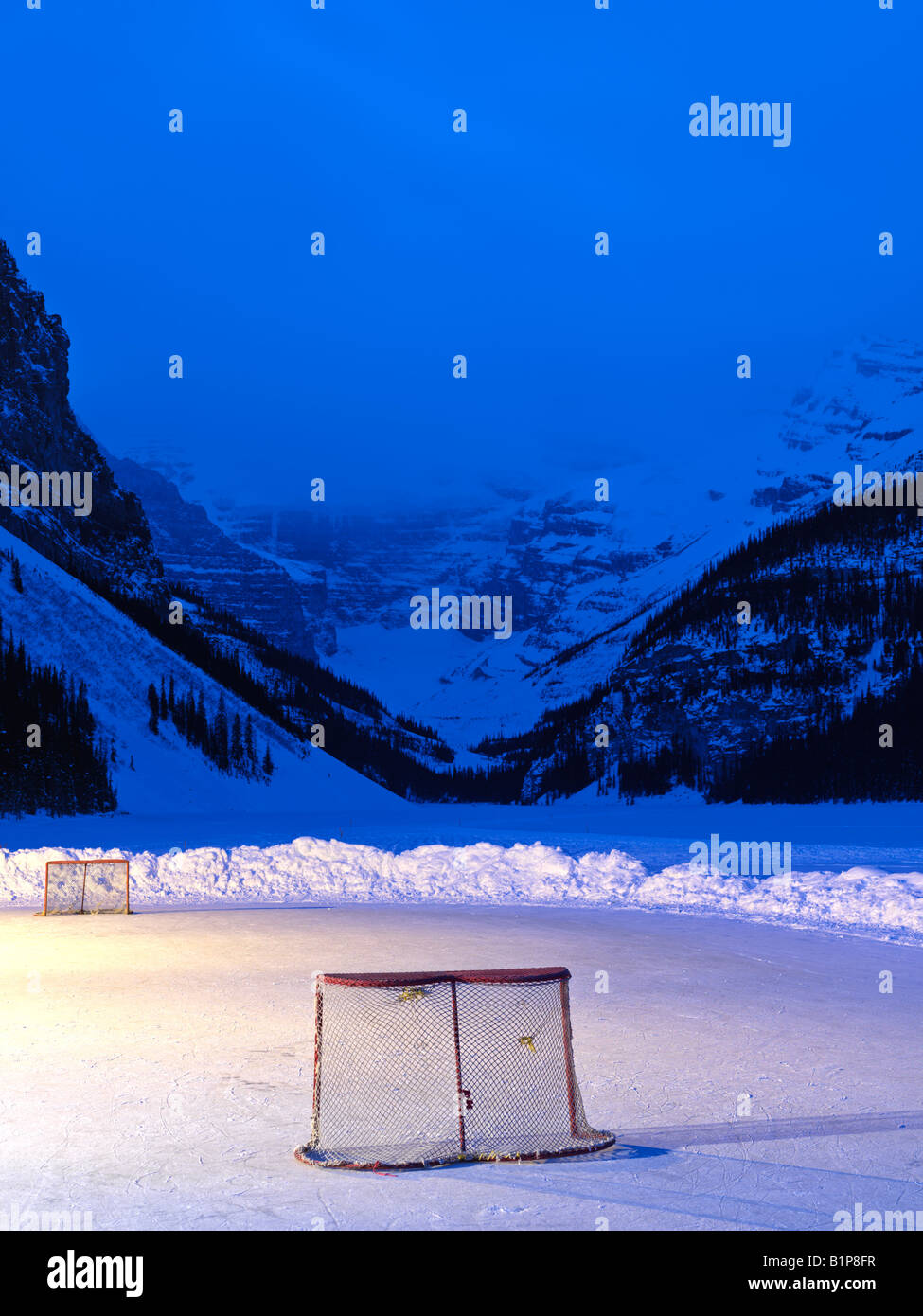 Canada Alberta Banff National Park Lake Louise ice rink with hockey nets on frozen Lake Louise at dawn Stock Photo