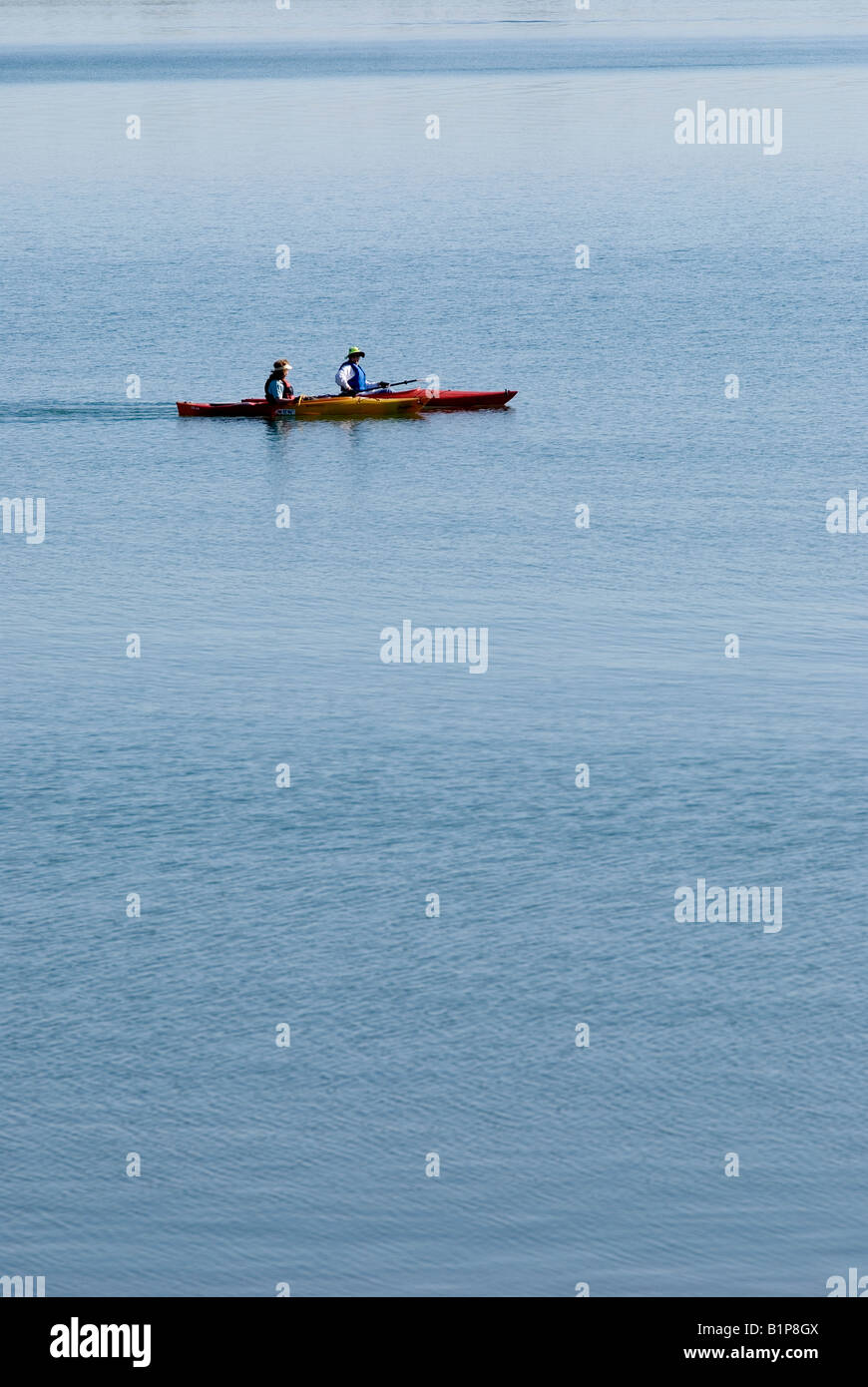 Two female kayakers paddle across the serene Boulder Reservoir in Boulder Colorado Stock Photo