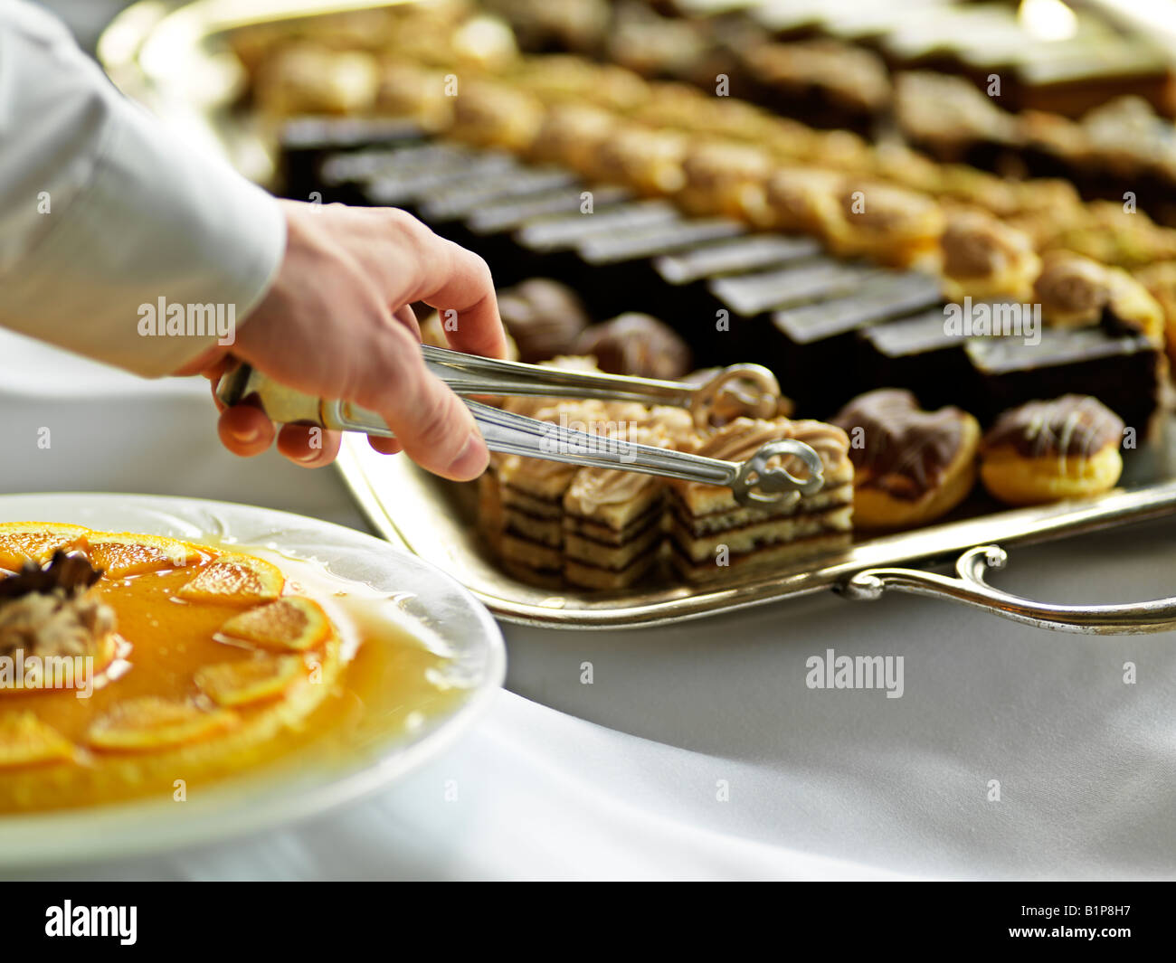 Canada Alberta Jasper Jasper Park Lodge dessert tray with hand and tong reaching for pastry Stock Photo