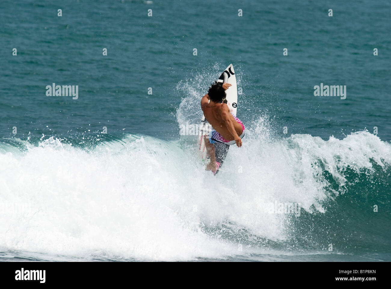 pro surfer Kalani Robb surfing in Bali a left hander green blue wave actioning a off the lip trick Stock Photo
