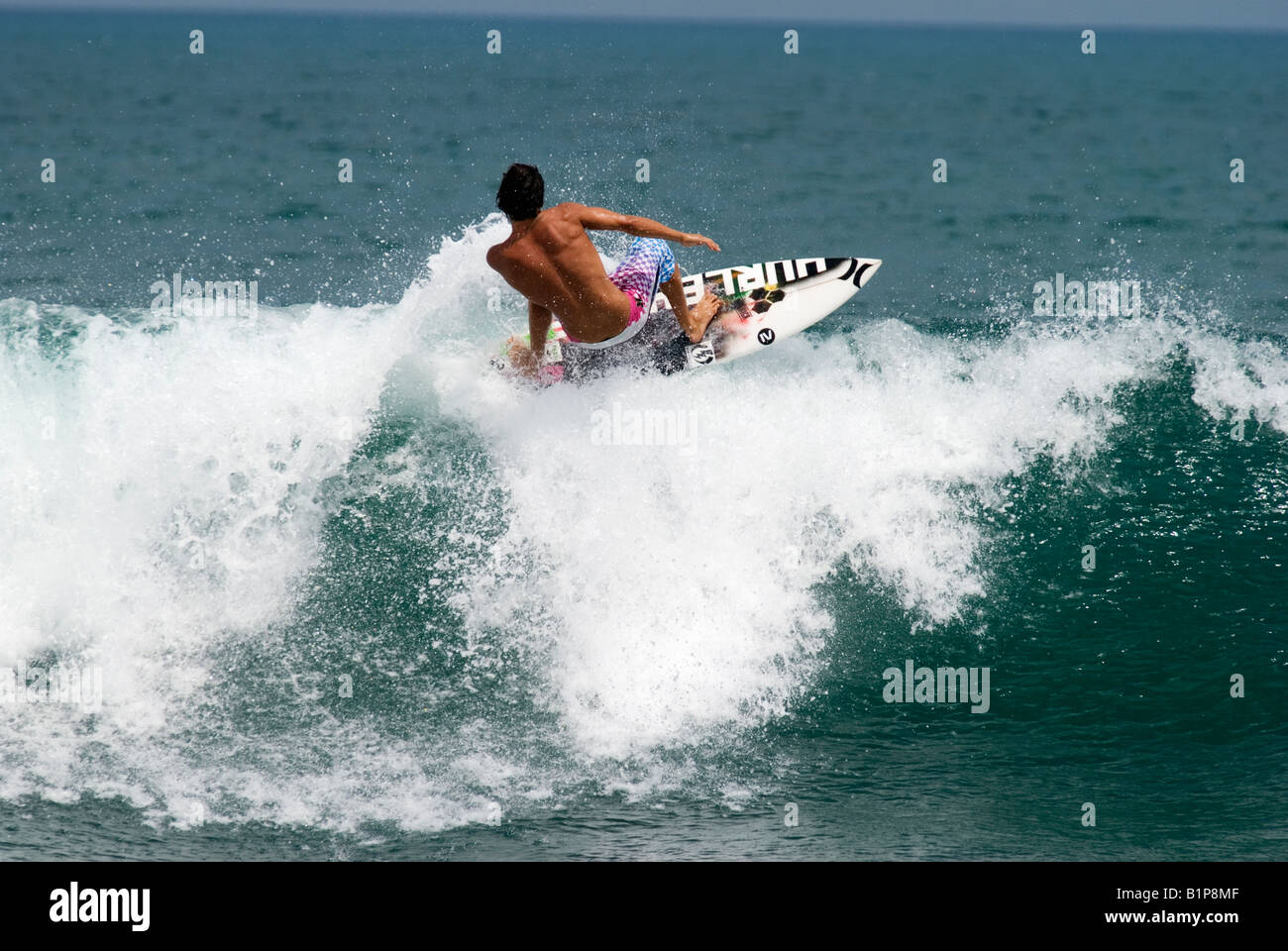 pro surfer Kalani Robb surfing in Bali a left hander green blue wave actioning a floater trick Stock Photo