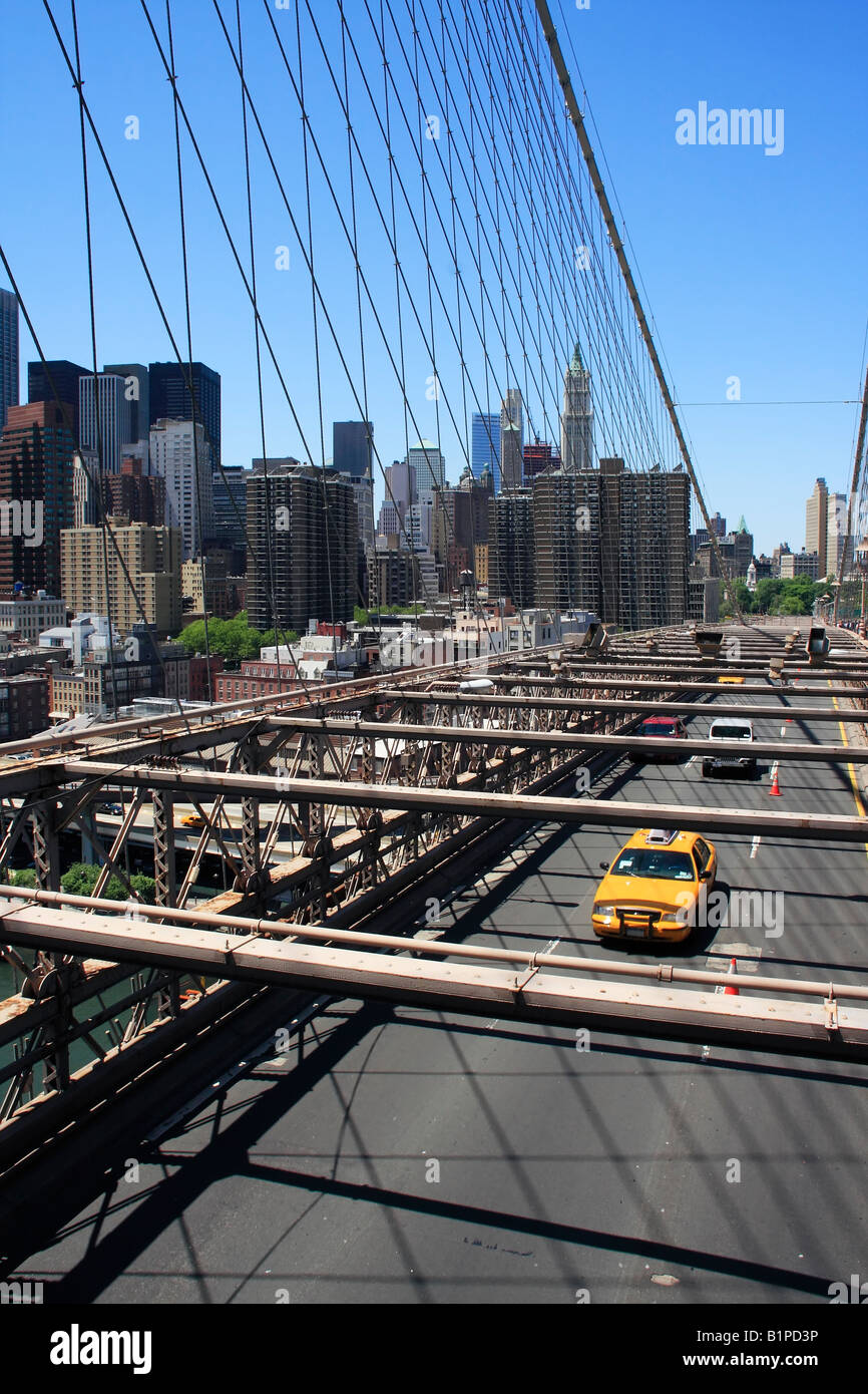 Yellow taxi on the Brooklyn bridge with Manhattan skyline in the background - New York City, USA Stock Photo
