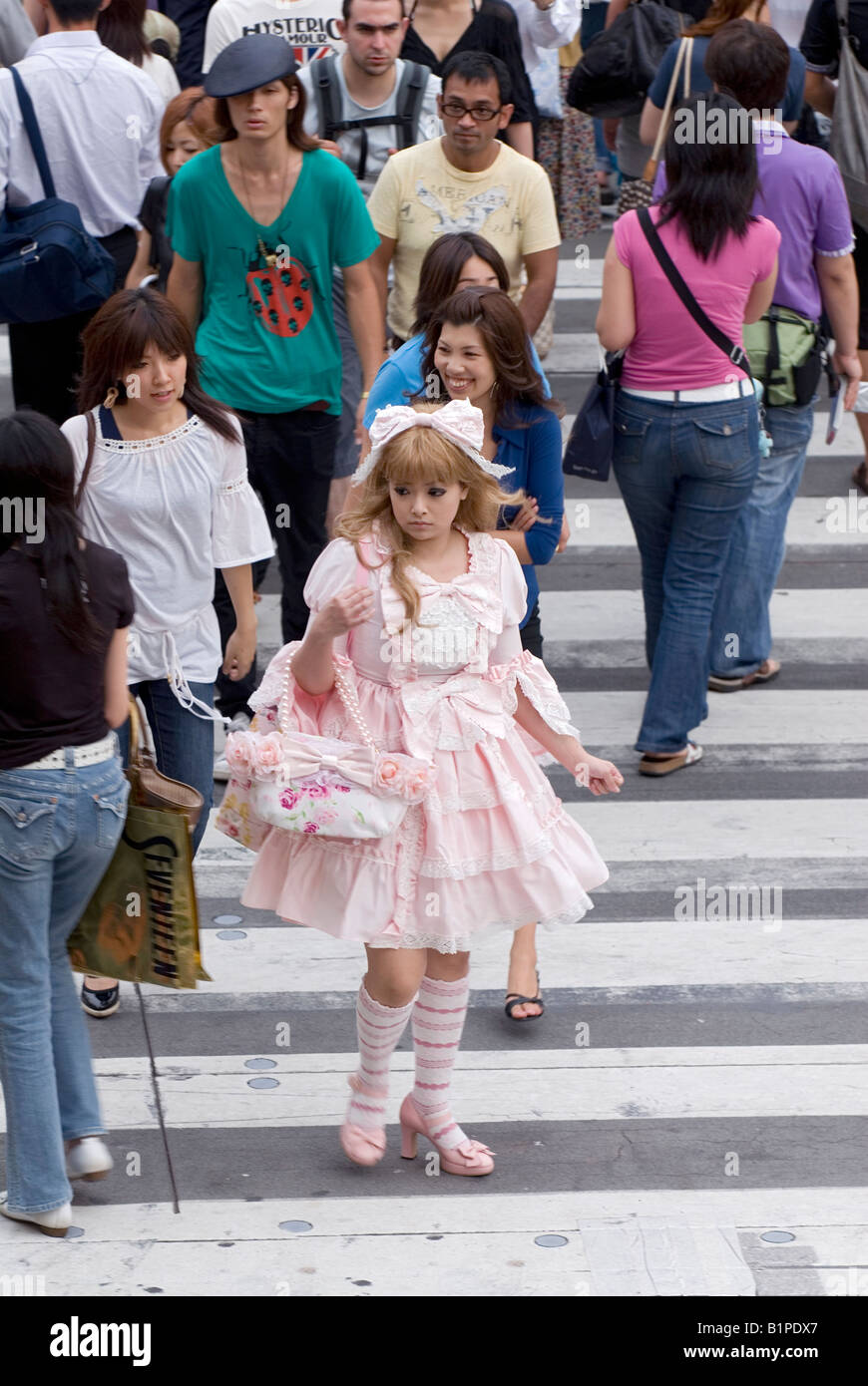 Girl dressed in frilly lolita-style fashion walking across a busy Tokyo street in the fashionable Aoyama Omotesando district Stock Photo