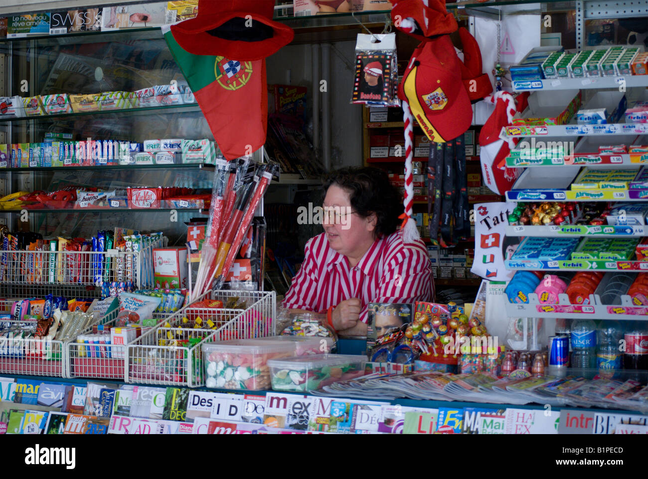Woman looking out from kiosk where she works Stock Photo