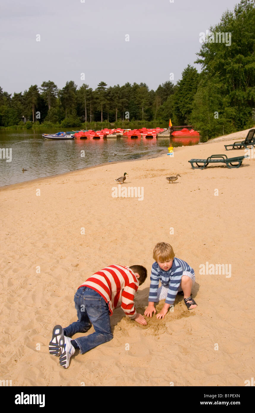 Boys Playing On Sand Area Of Lake At Center Parcs at Elveden near