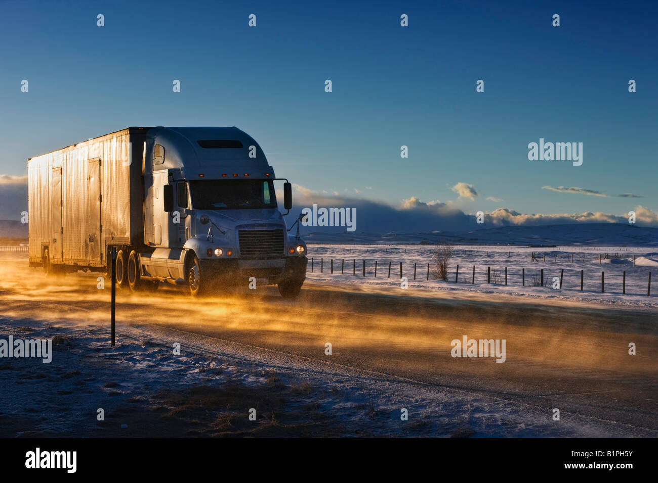 A truck driving across the frozen plains of Wyoming in the middle of winter. Stock Photo