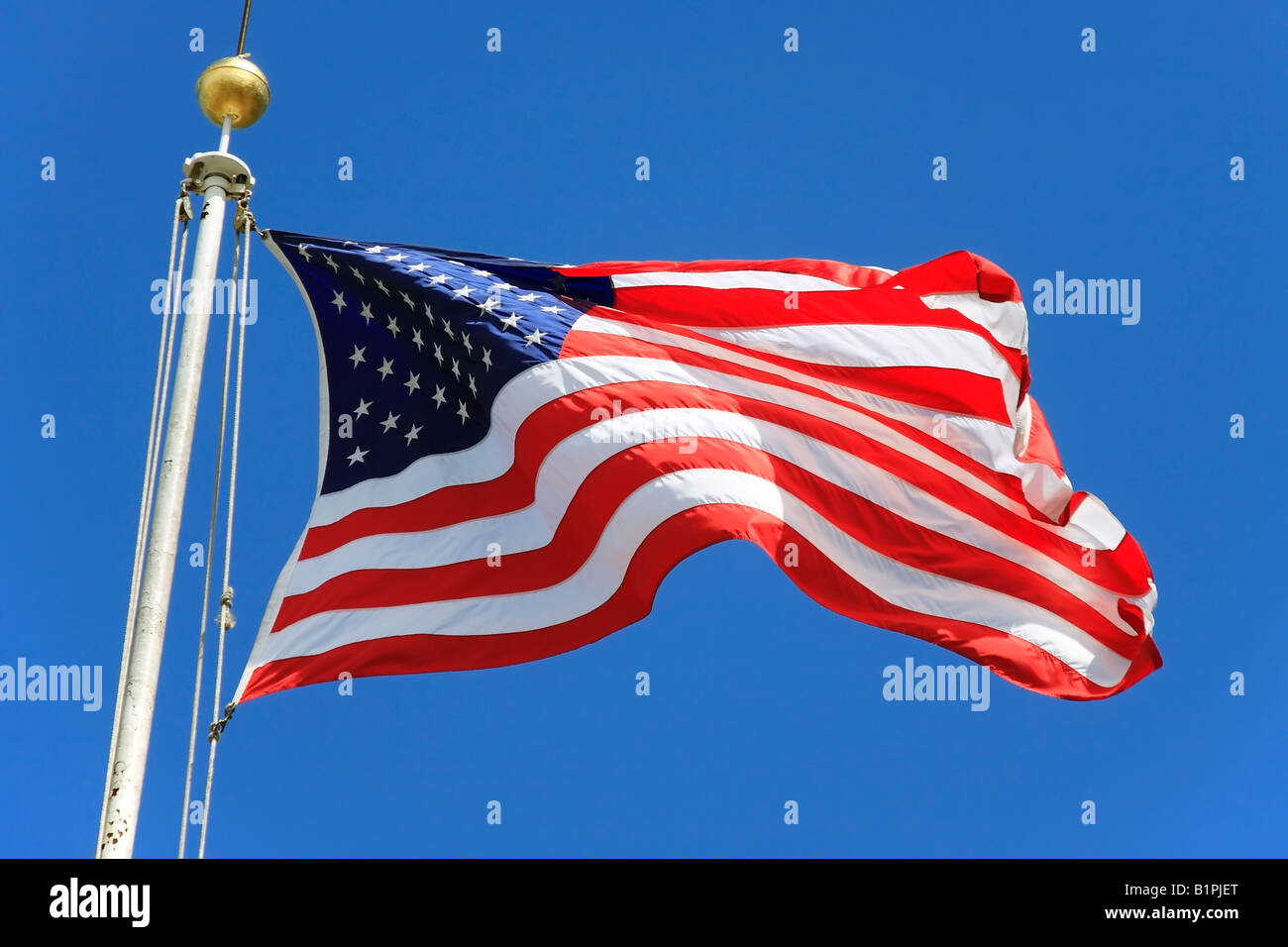 USA flag waving over a blue sky in Battery Park - New York City, USA Stock Photo