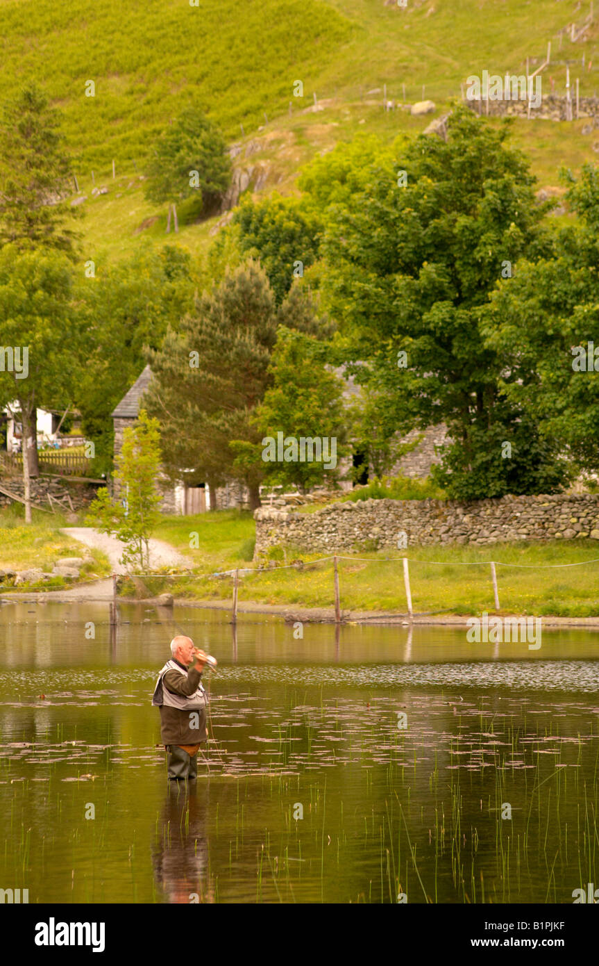 Man fly fishing on Watendlath Tarn in Summer Keswick Lake District
