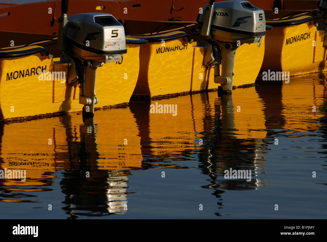 Painted rowing boats reflected in the calm waters of the River Thames