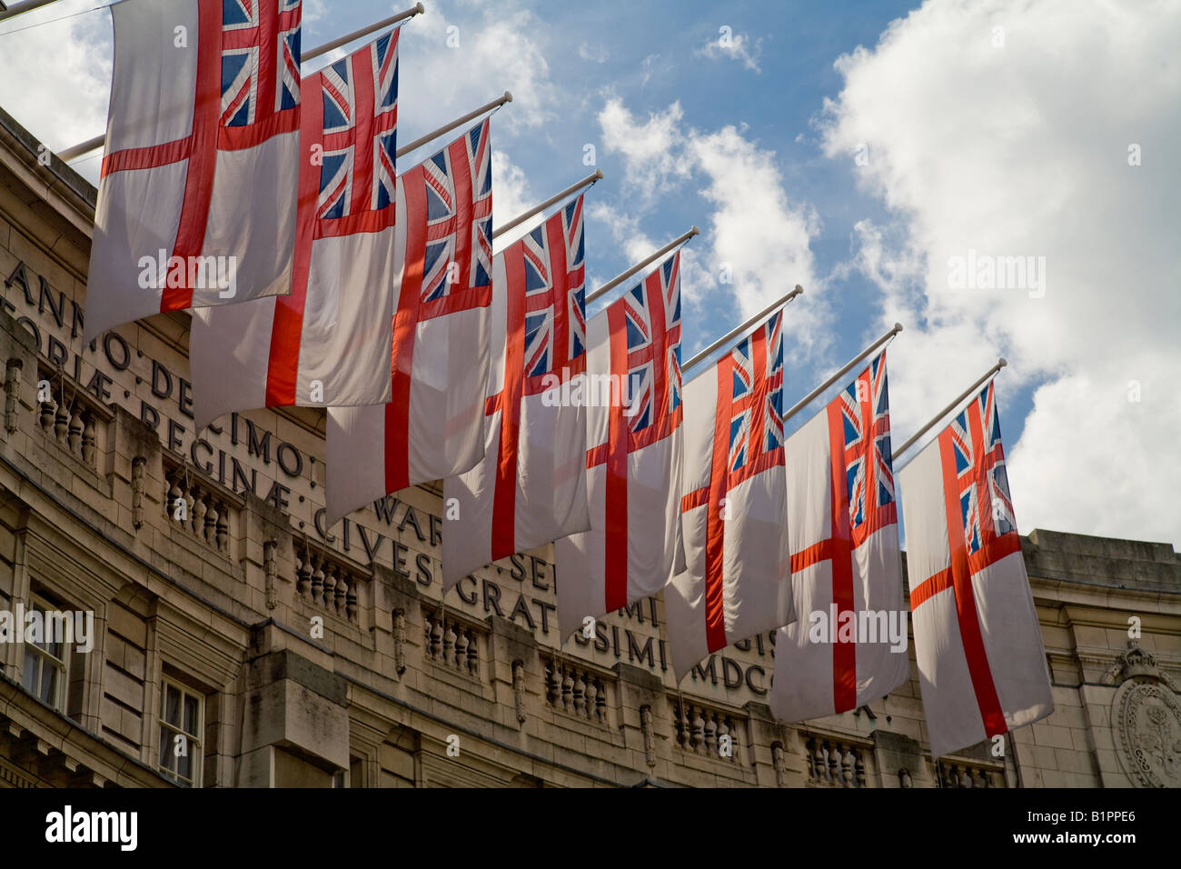 The White Ensign the flag of the Royal Navy flies from the top of Admiralty Arch in the afternoon sunshine Stock Photo