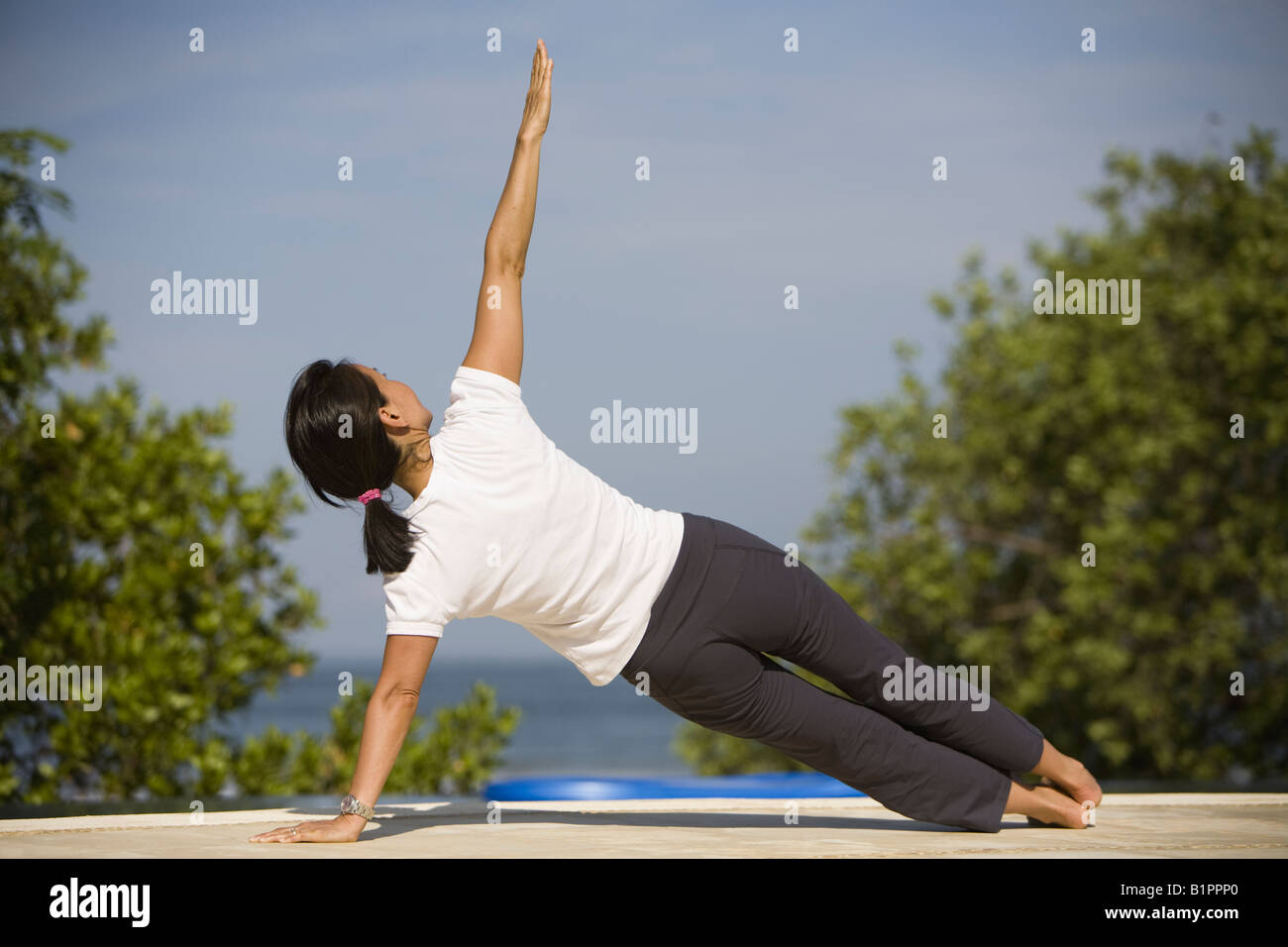 Asian woman exercising on the pool deck Stock Photo