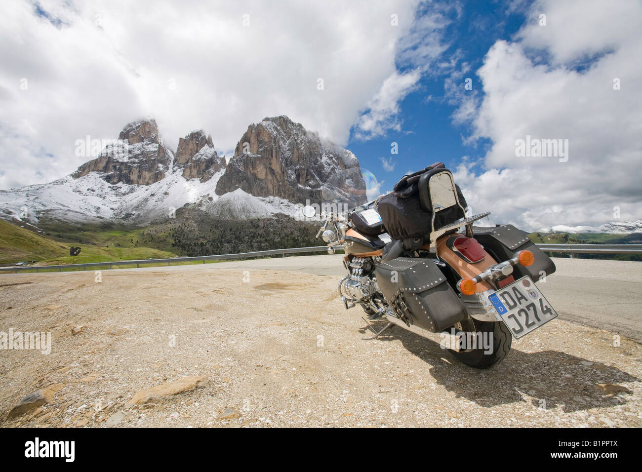 A Motorbike on the summit of the Sella Joch pass in the Italian Dolomites with mountain view behind Stock Photo