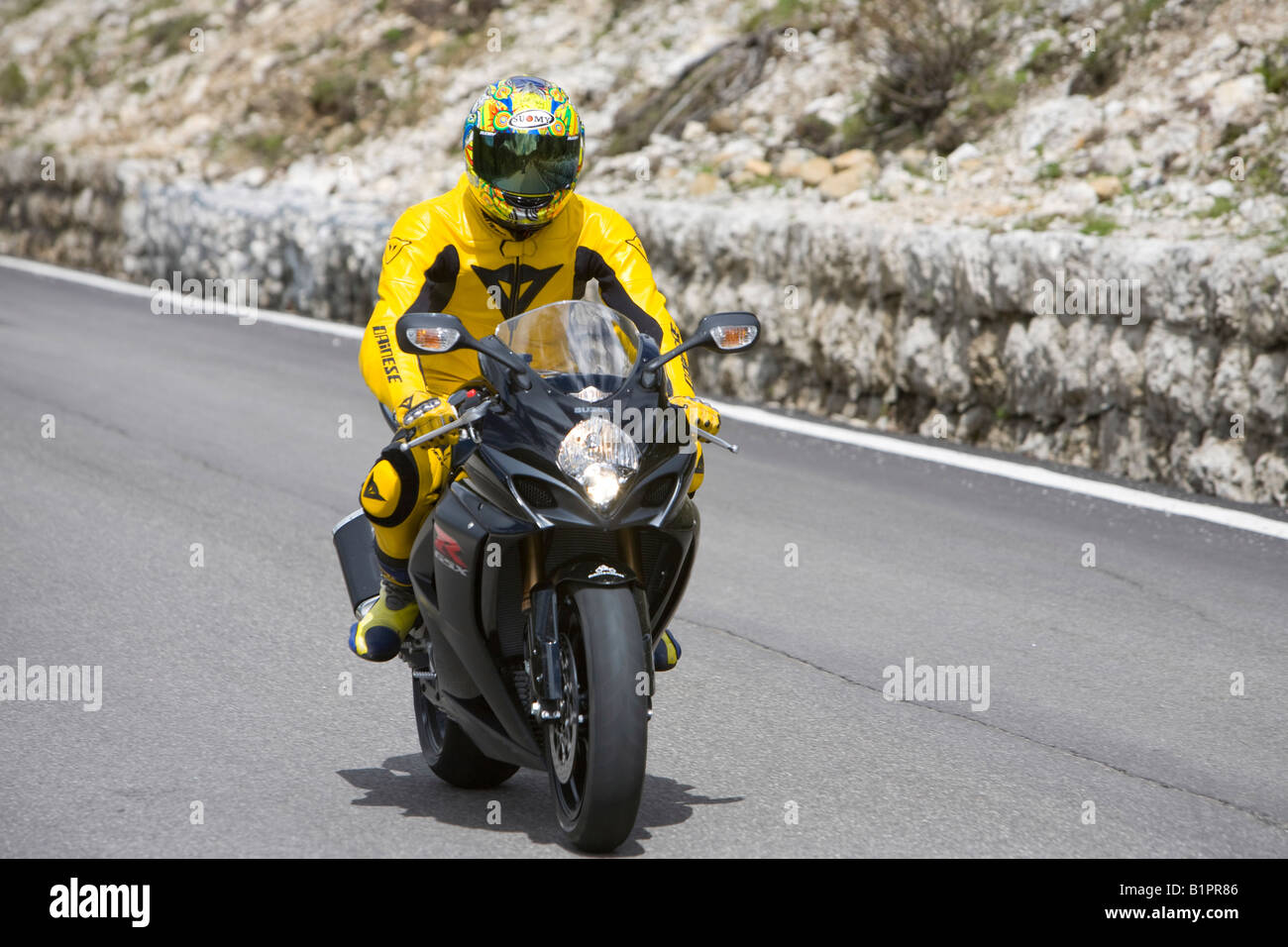 Motorbike rider climbing the Sella Joch pass in the Italian Dolomites Stock Photo
