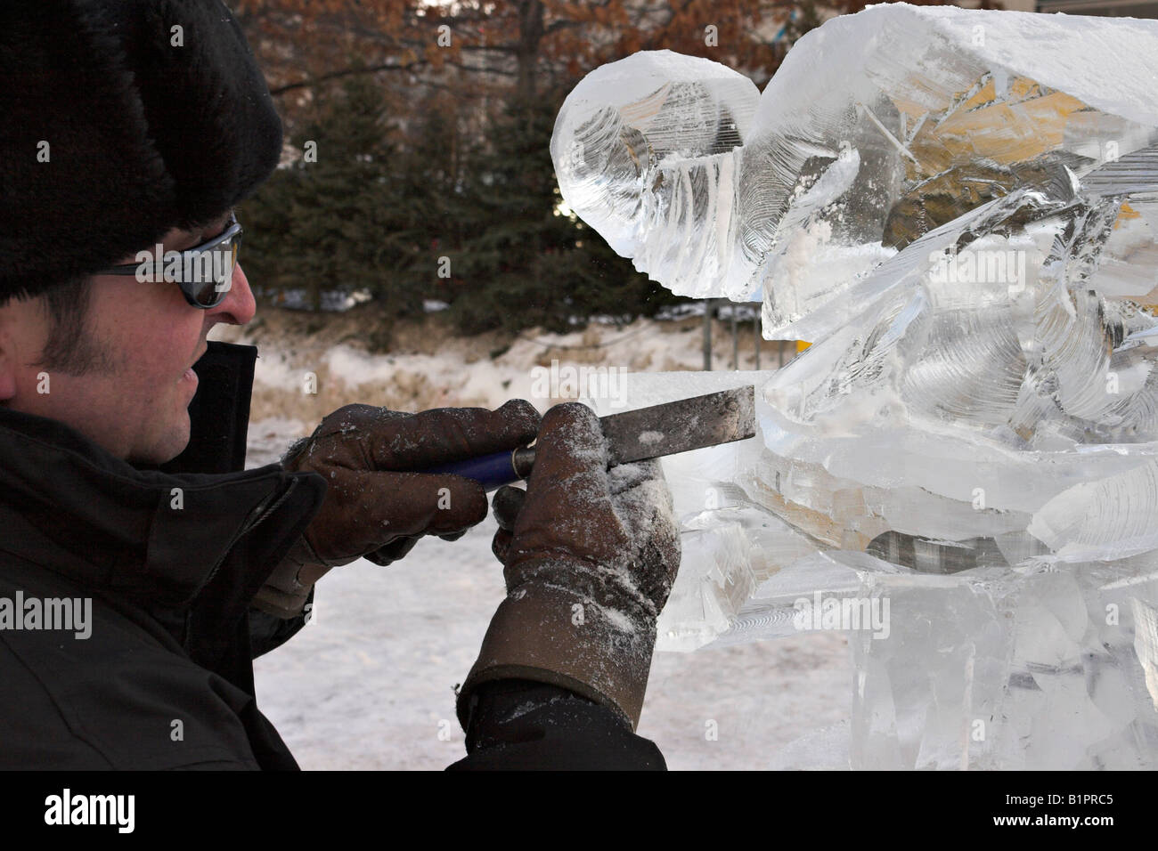 Fine Detail: Quebec sculptor Daniel Gaudreault takes a chisel to do some fine touch ups on his winterlude ice carving Stock Photo