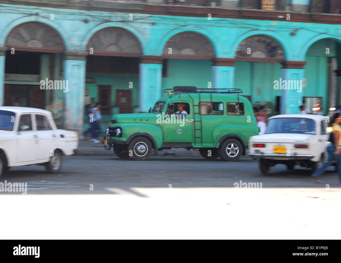 Classic American car drives past Spanish Colonial arches and Lada Rivas in Havana Cuba Stock Photo