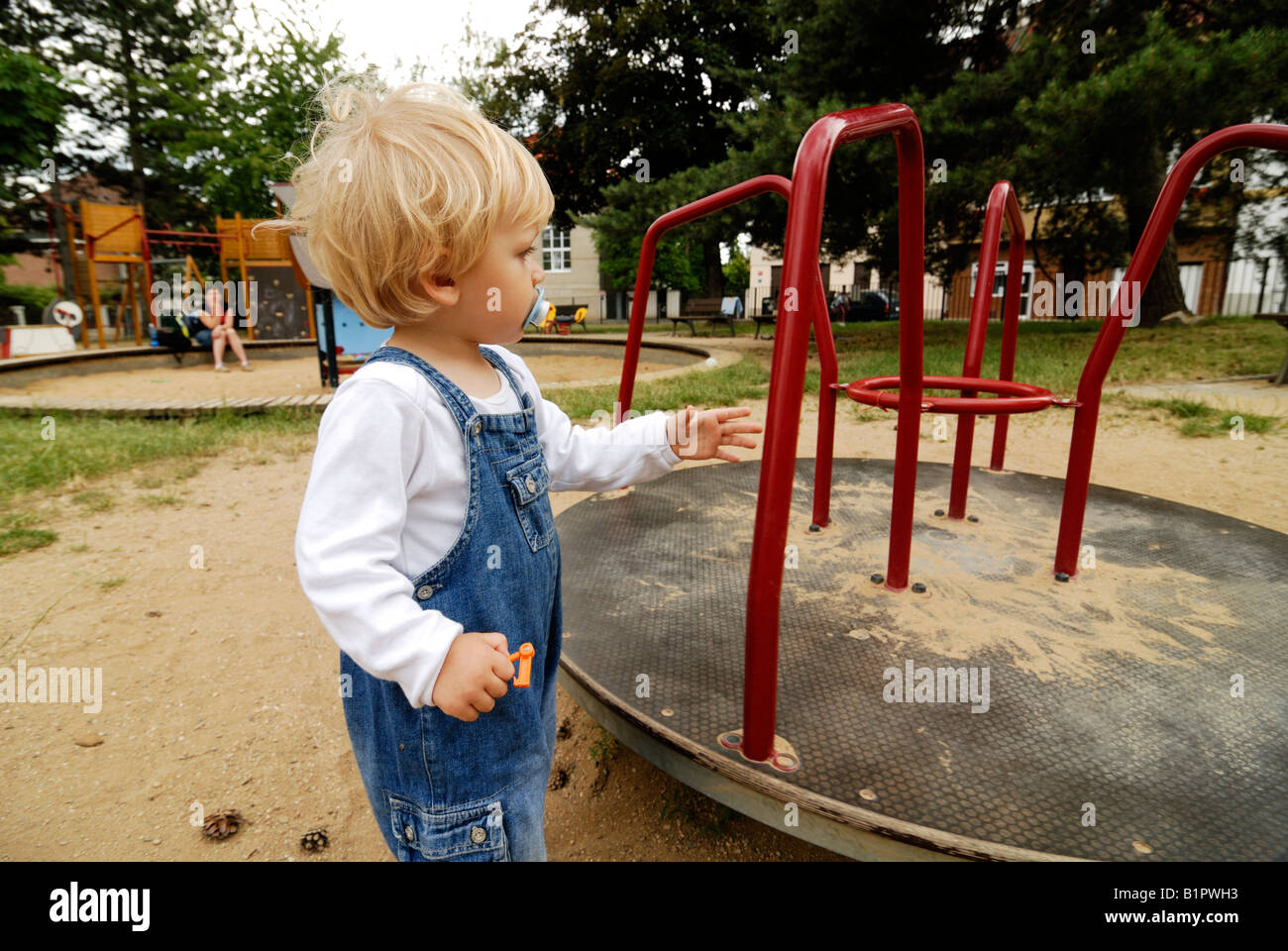 Baby in sand pit playing toys playground Stock Photo