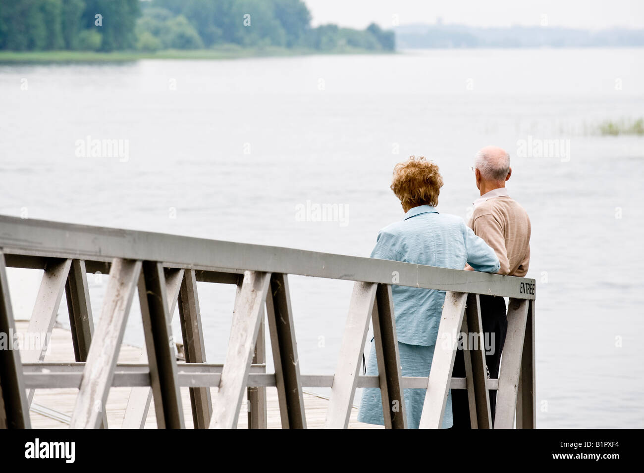 Old couple await the arrival of a ferry Stock Photo