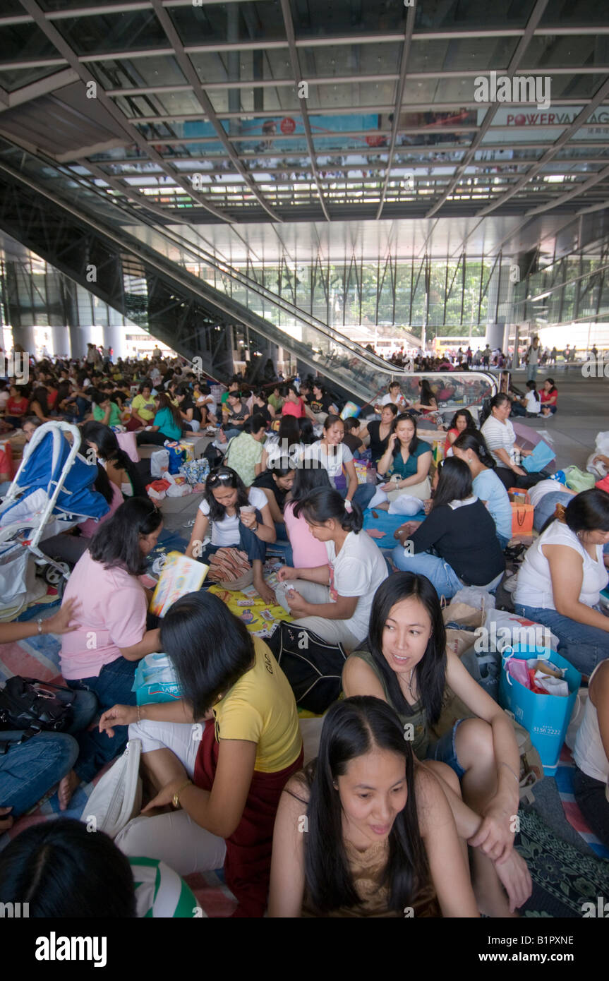 Domestic helpers gather under the shelter of the HSBC building on their