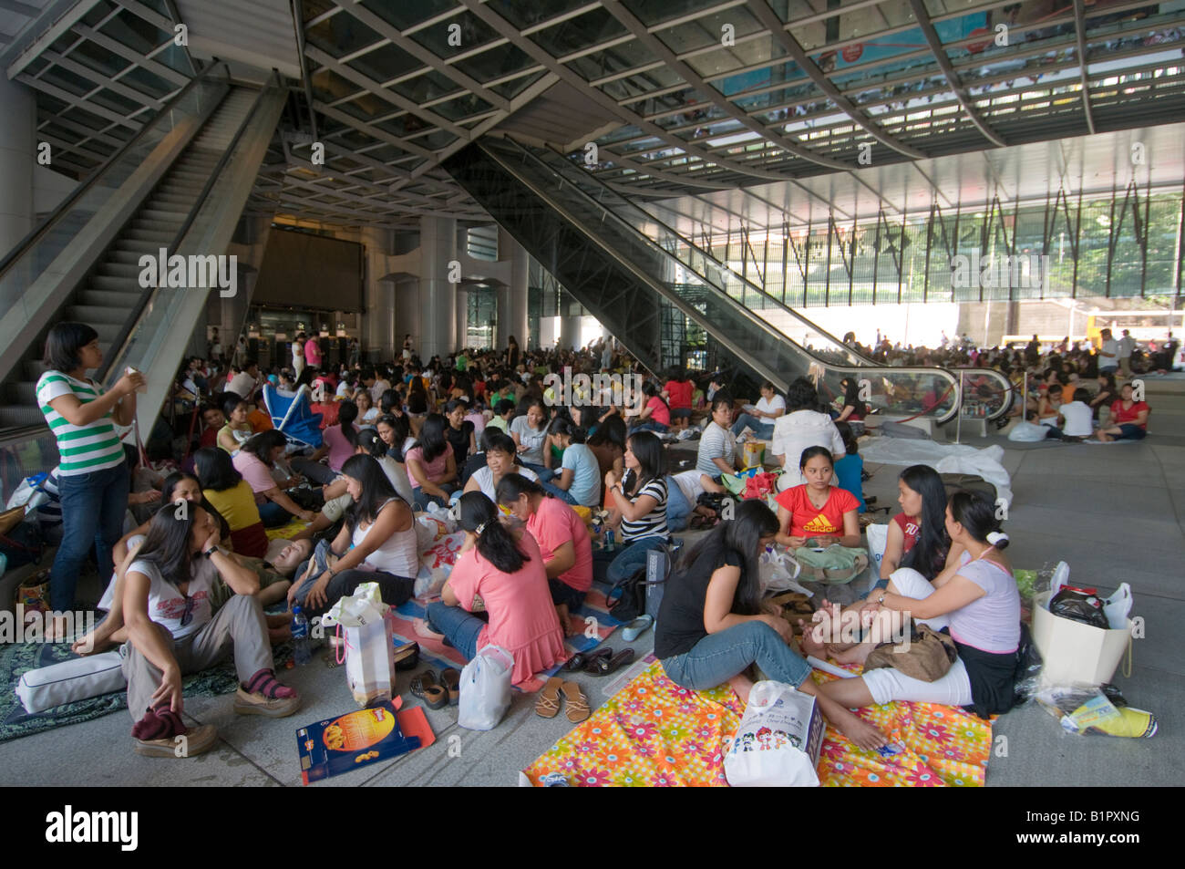 Domestic helpers gather under the shelter of the HSBC building on their